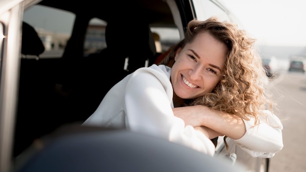 Mujer sentada en un auto y sonrisas