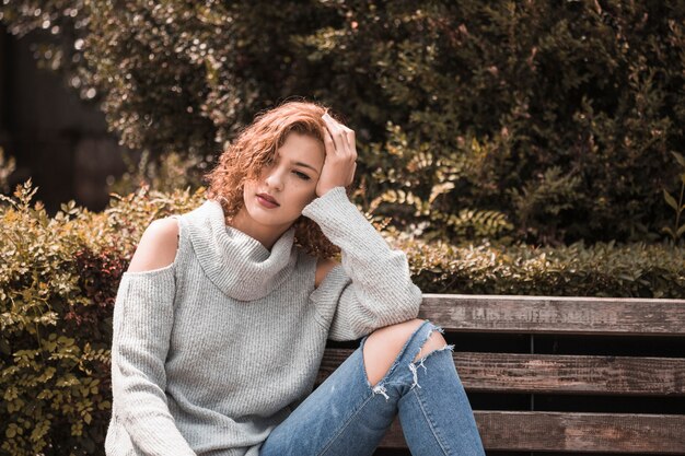 Mujer sentada en el banco en el parque