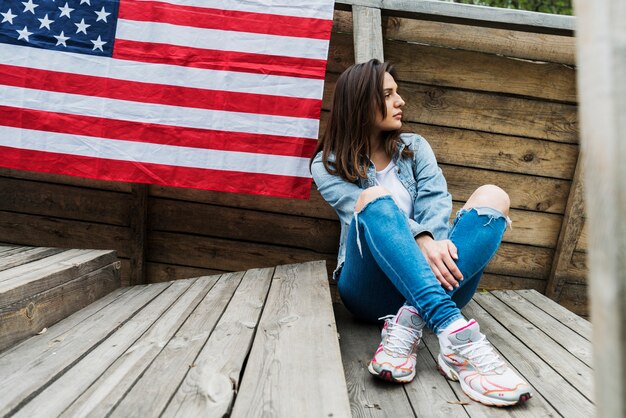 Mujer sentada y bandera americana