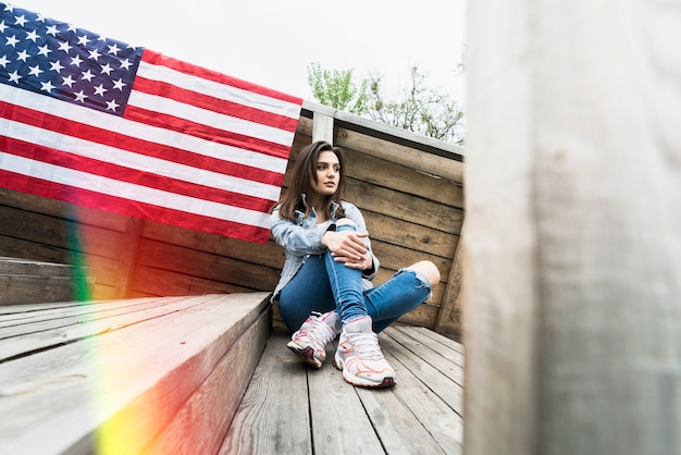 Mujer sentada y bandera americana