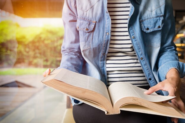 Mujer sentada en un café, leyendo el libro