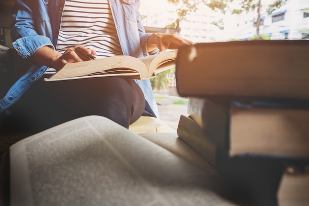 Mujer sentada en un café, leyendo el libro