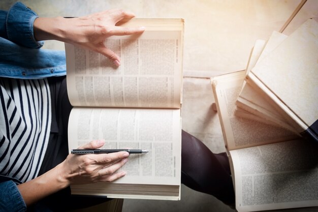 Mujer sentada en un café, leyendo el libro