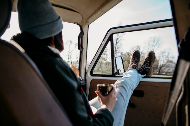 Foto gratuita mujer sentada en una camioneta con las piernas hacia fuera