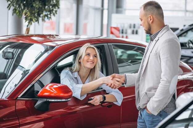 Mujer sentada en el carro y recibiendo llaves