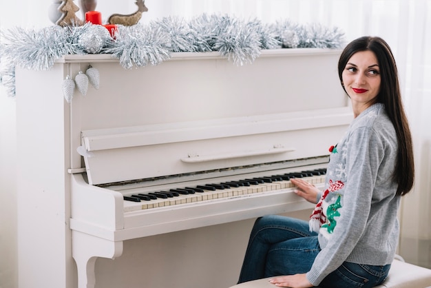 Foto gratuita mujer sentada cerca de piano