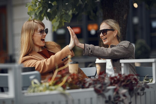 Mujer sentada en una ciudad de verano y tomando café