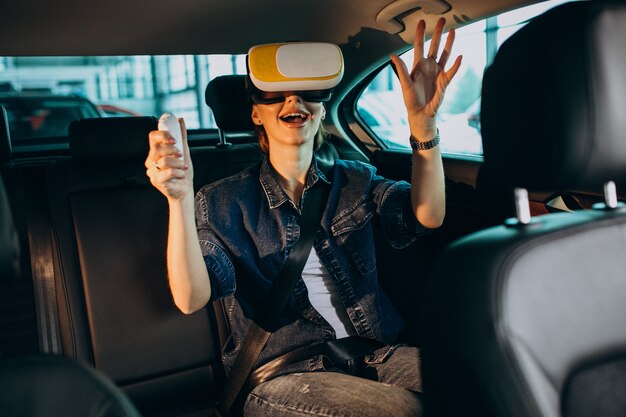 Mujer sentada dentro de un automóvil con gafas vr