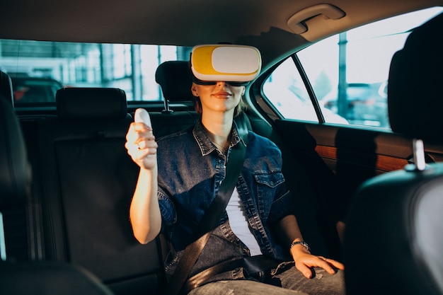 Mujer sentada dentro de un automóvil con gafas vr