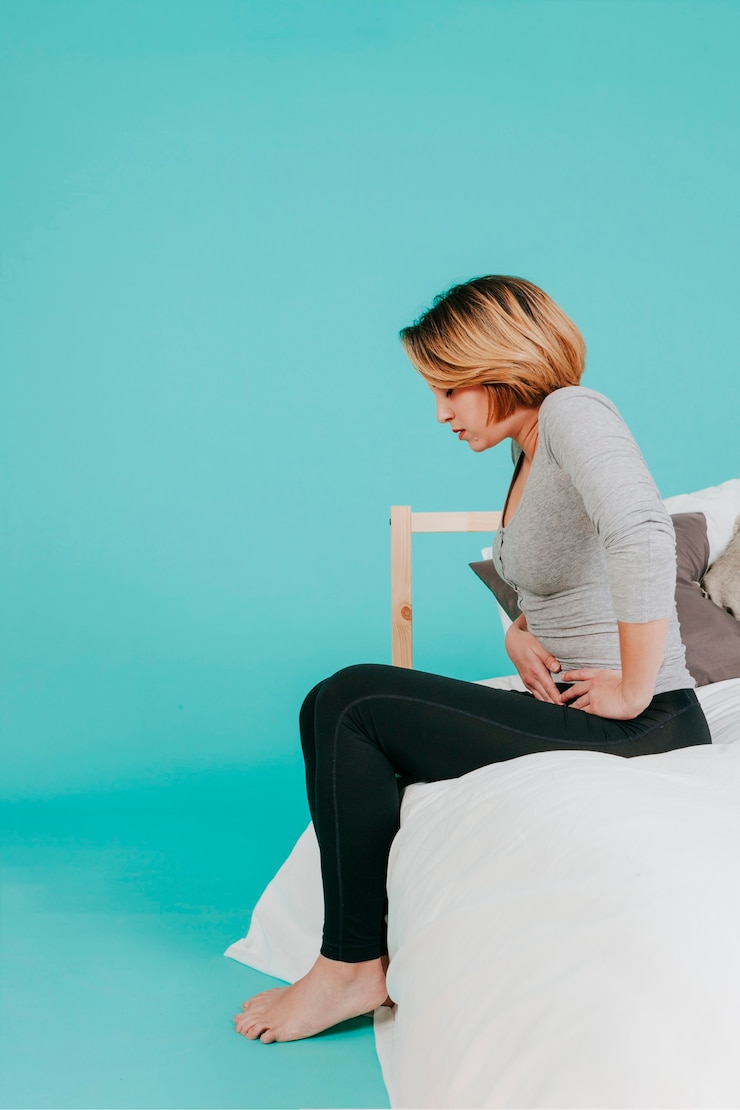 Foto gratuito mujer sentada con dolor en el estómago