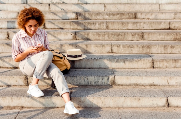 Mujer sentada en las escaleras con espacio de copia