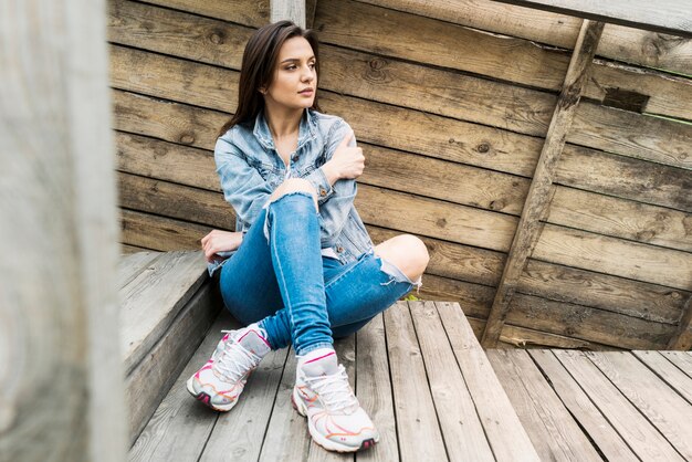 Mujer sentada en escaleras de madera