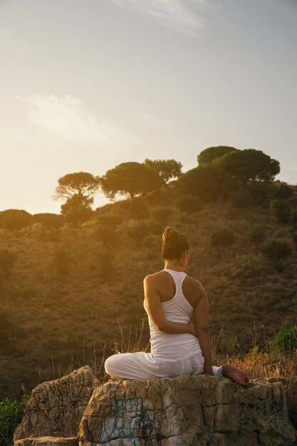 Mujer sentada y estirando en la naturaleza