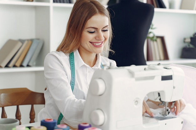 Mujer sentada en estudio y coser tela