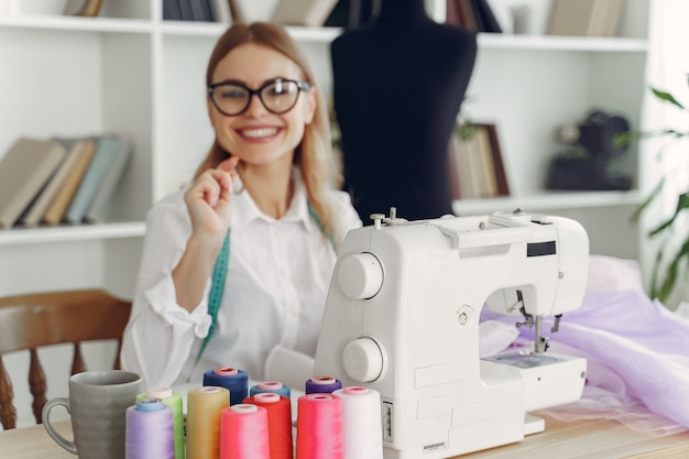 Mujer sentada en estudio y coser tela