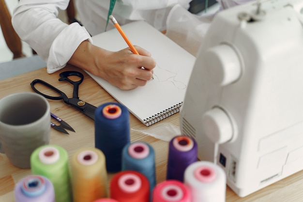 Mujer sentada en estudio y coser tela