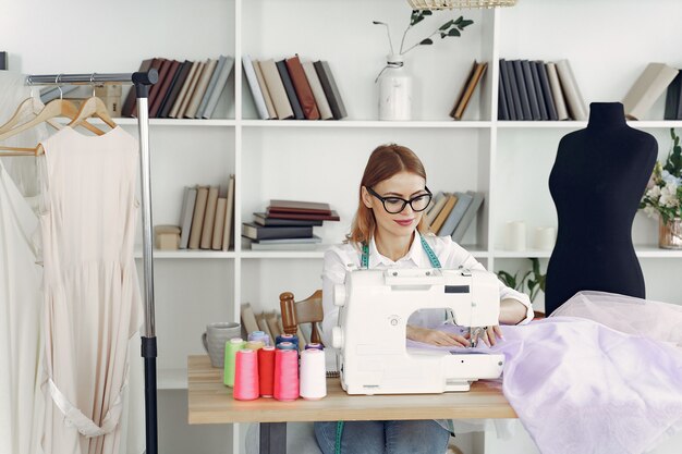 Mujer sentada en estudio y coser tela