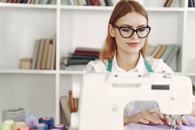 Mujer sentada en estudio y coser tela