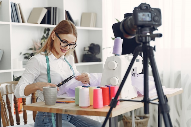 Mujer sentada en estudio y coser tela