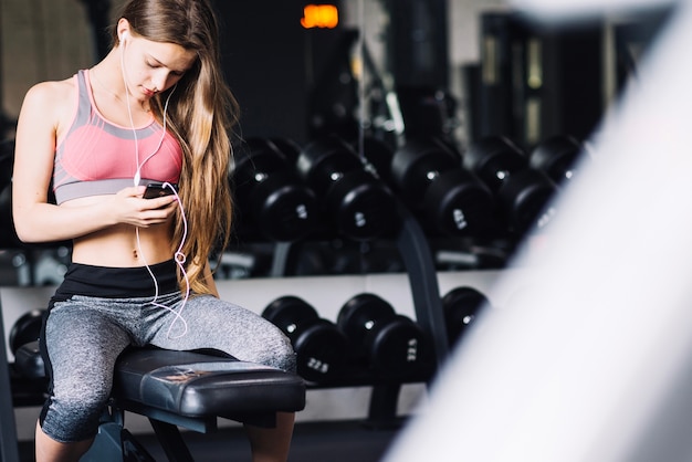 Foto gratuita mujer sentada en el gimnasio