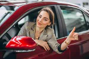 Foto gratuita mujer sentada i coche en un coche showrrom