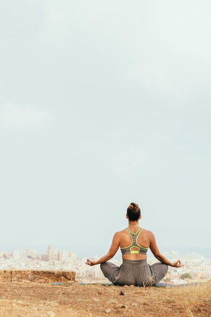 Mujer sentada y meditando en la naturaleza