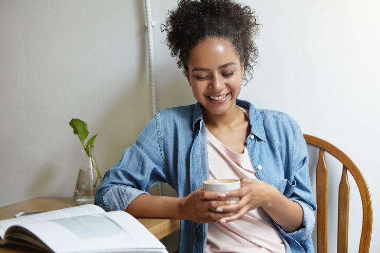 Foto gratuito mujer sentada en una mesa con un libro