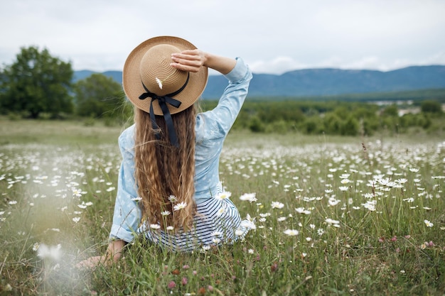 mujer sentada en la parte de atrás con el pelo largo en el campo