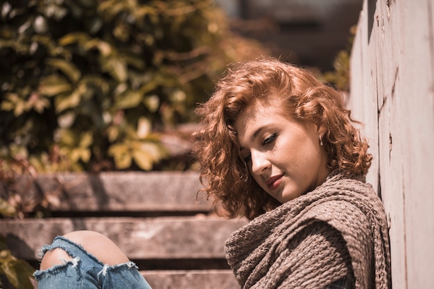 Foto gratuita mujer sentada en pasos con la cabeza flexionada