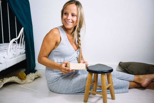 Foto gratuita mujer sentada en el piso en el cuarto de niños