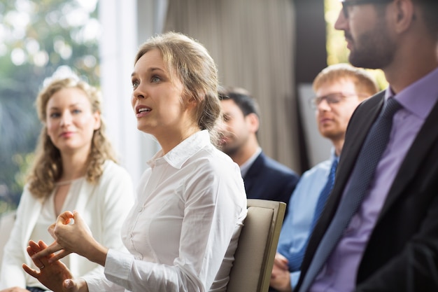 Mujer sentada en el público hablando