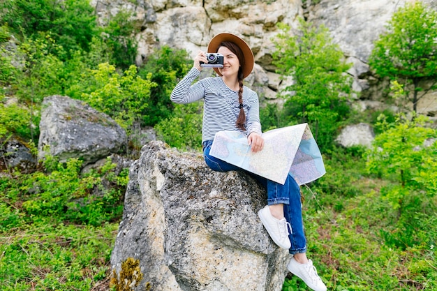 Mujer sentada en roca en la naturaleza