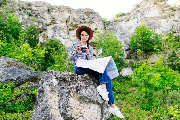 Mujer sentada en roca en la naturaleza