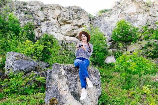 Mujer sentada en roca en la naturaleza