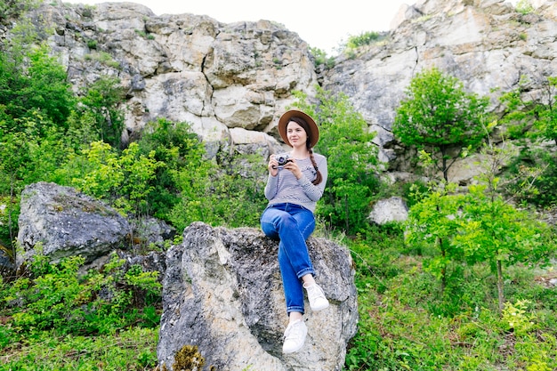 Mujer sentada en roca en la naturaleza