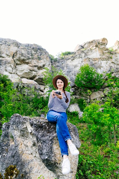 Mujer sentada en roca en la naturaleza