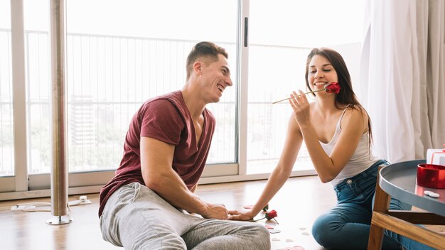 Mujer sentada con rosa en el piso