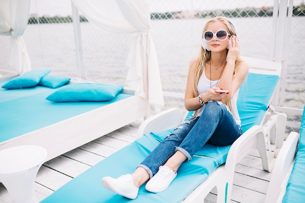 Foto gratuita mujer sentada en el salón con auriculares