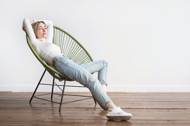 Foto gratuita mujer sentada en una silla de tiro largo