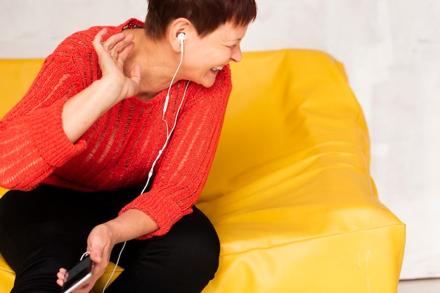 Foto gratuita mujer sentada en el sofá y escuchando música