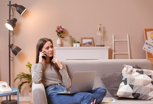 Mujer sentada en el sofá y trabajando