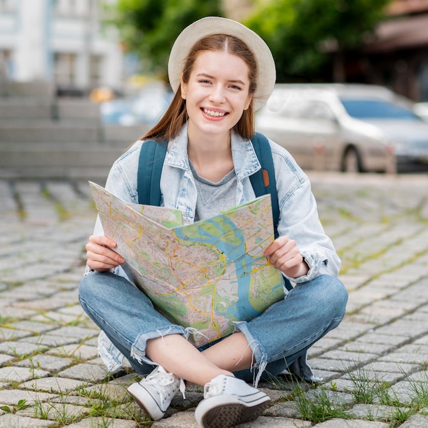 Mujer sentada y sosteniendo un mapa