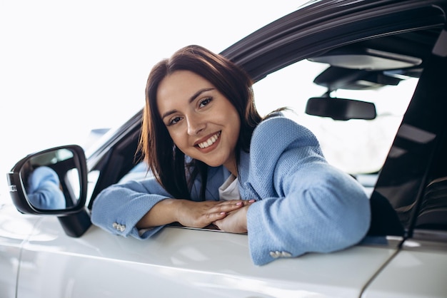 Foto gratuita mujer sentada en su auto nuevo