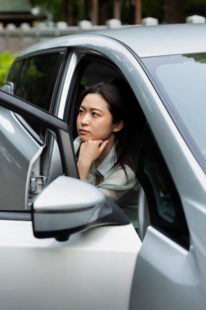 Mujer sentada en su coche eléctrico