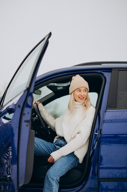 Mujer sentada en su coche nuevo en un parque de invierno