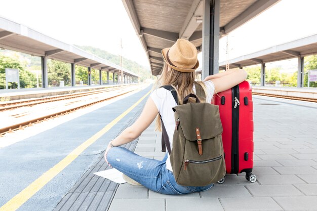 Mujer sentada en el suelo en la estación de tren