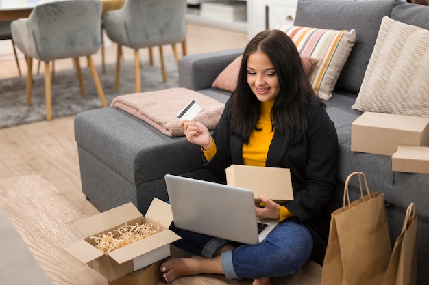 Mujer sentada en el suelo mientras realiza una nueva compra