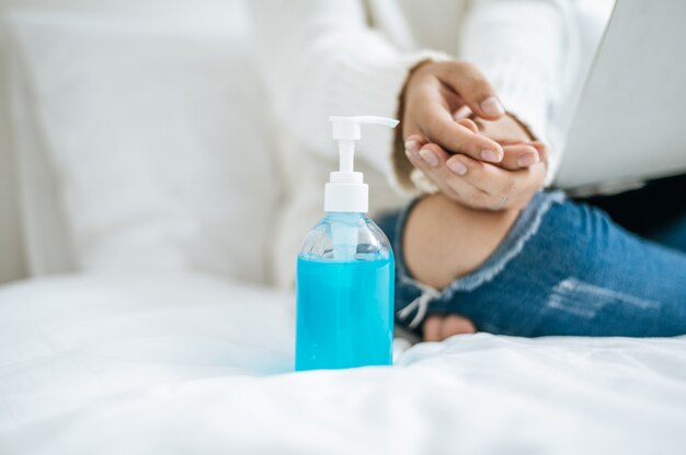 Foto gratuita la mujer se sentó en la cama y se lavó a mano el gel.