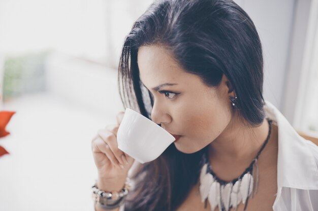 Mujer seria bebiendo de una taza de café