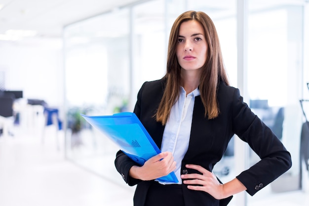 Mujer seria con una carpeta azul